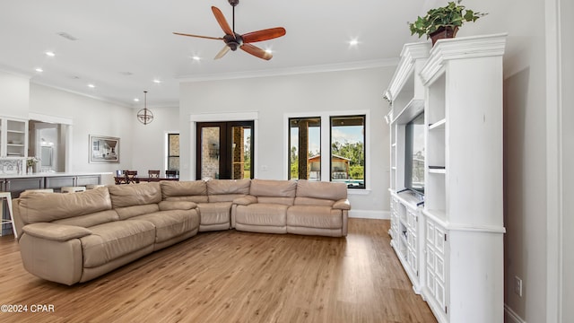 living room featuring ornamental molding, light wood-type flooring, and ceiling fan