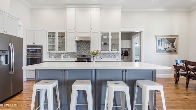 kitchen featuring a kitchen breakfast bar, an island with sink, and stainless steel appliances