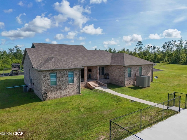 view of front of property featuring central AC unit and a front lawn