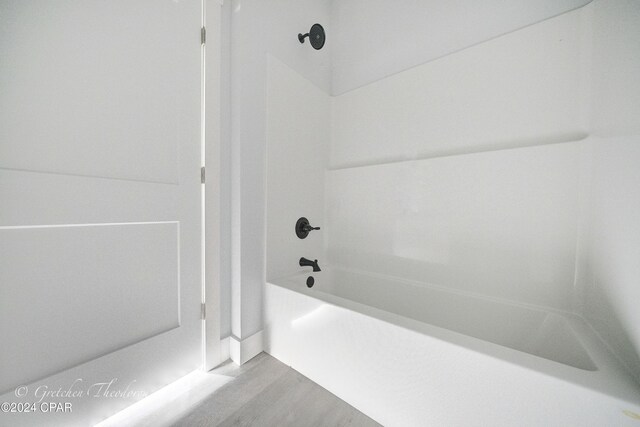 bathroom with wood-type flooring and bathtub / shower combination