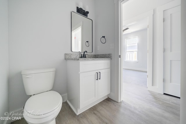 bathroom featuring vanity, wood-type flooring, and toilet