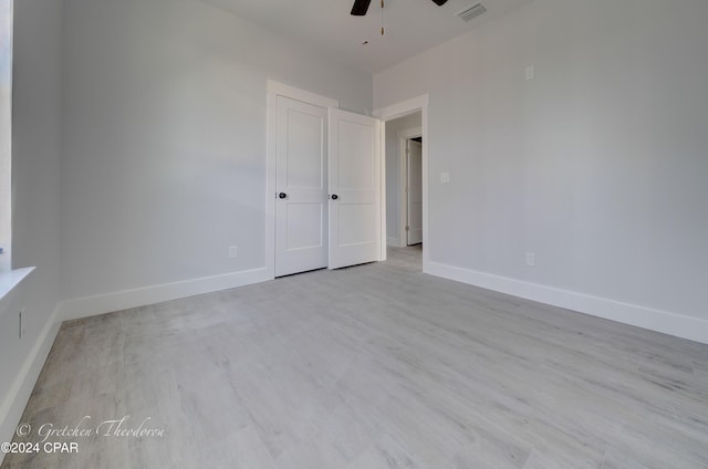 unfurnished bedroom with ceiling fan and light wood-type flooring