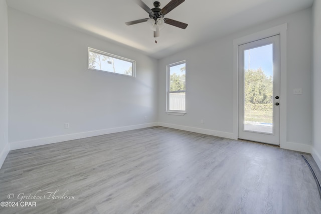 empty room featuring plenty of natural light, light hardwood / wood-style floors, and ceiling fan