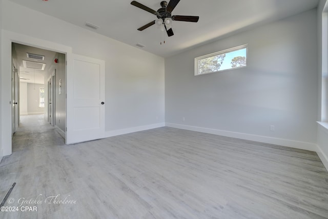 unfurnished room with ceiling fan, a wealth of natural light, and light wood-type flooring