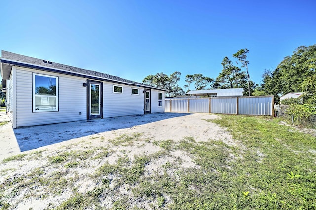 rear view of property featuring a yard