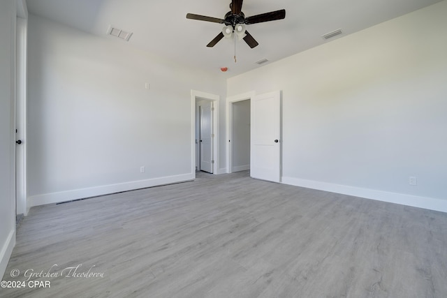 empty room with ceiling fan and light hardwood / wood-style flooring