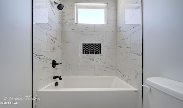 bathroom featuring tiled shower / bath and toilet