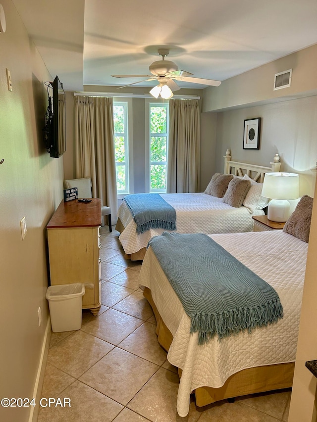 tiled bedroom featuring ceiling fan