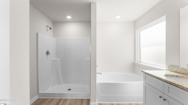 bathroom featuring wood-type flooring, vanity, and shower with separate bathtub