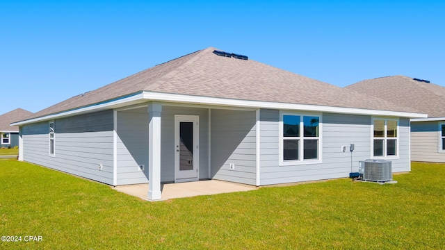 rear view of property featuring a lawn and central AC