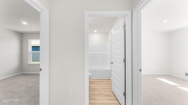 hall featuring light colored carpet