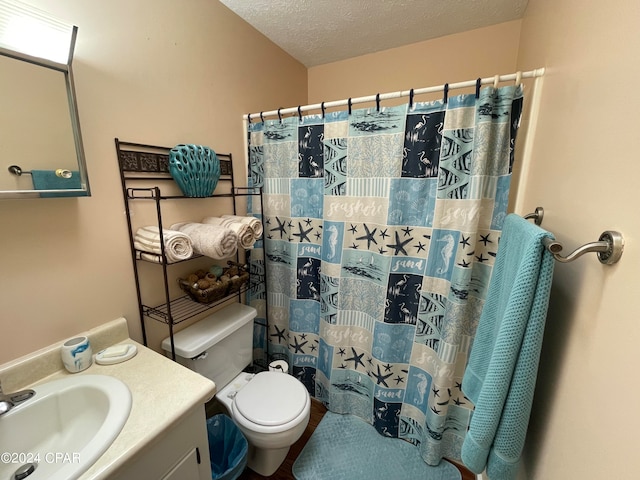 bathroom with vanity, toilet, curtained shower, and a textured ceiling