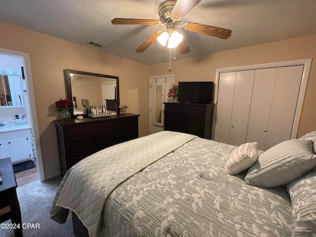 bedroom featuring a textured ceiling, carpet flooring, connected bathroom, and ceiling fan