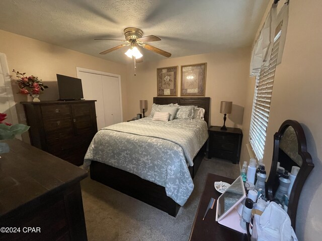 carpeted bedroom featuring a closet, ceiling fan, and a textured ceiling