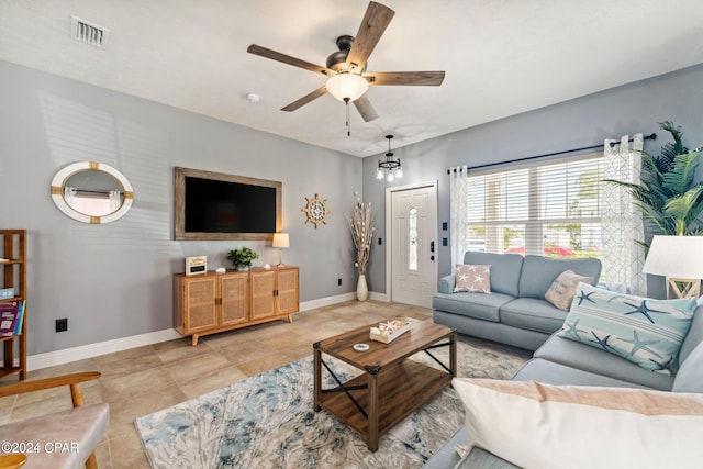 living room featuring ceiling fan with notable chandelier and light tile patterned floors