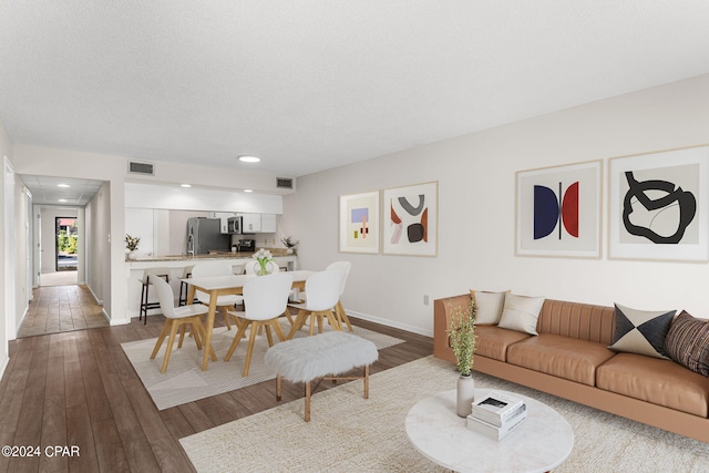 living room with dark hardwood / wood-style flooring and a textured ceiling