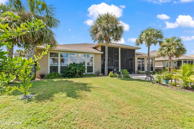 back of property featuring a sunroom and a lawn