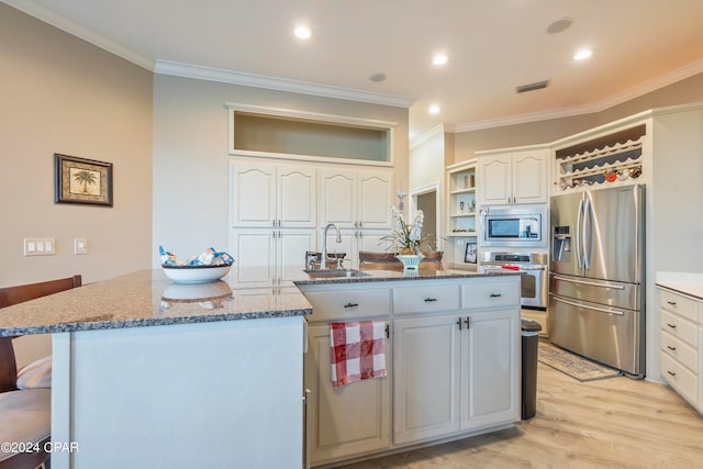 kitchen featuring white cabinets, light wood-type flooring, stainless steel appliances, sink, and ornamental molding