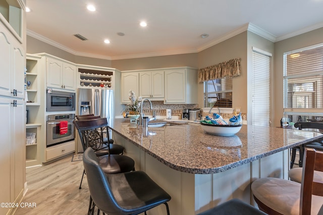 kitchen with white cabinetry, backsplash, kitchen peninsula, appliances with stainless steel finishes, and light hardwood / wood-style floors