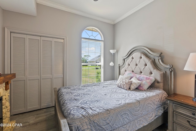 bedroom with a closet, dark hardwood / wood-style floors, and crown molding