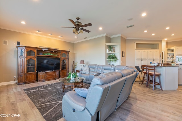 living room featuring ceiling fan, light hardwood / wood-style floors, and crown molding