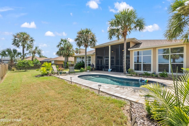 view of swimming pool featuring a sunroom, a lawn, and a patio