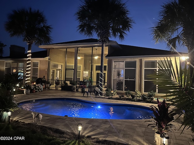 pool at twilight with a patio area, an outdoor pool, and french doors