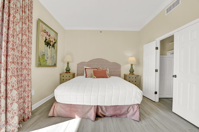 bedroom featuring crown molding and light hardwood / wood-style flooring