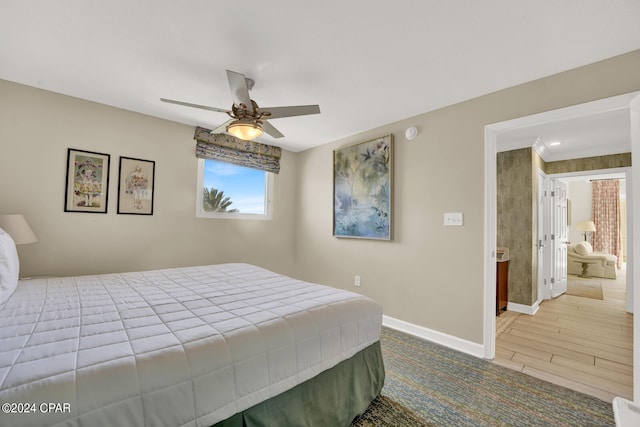 bedroom with ceiling fan, ensuite bath, and wood-type flooring