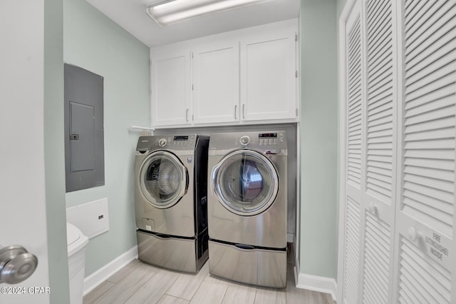 laundry area featuring light wood-type flooring, washer and dryer, and electric panel