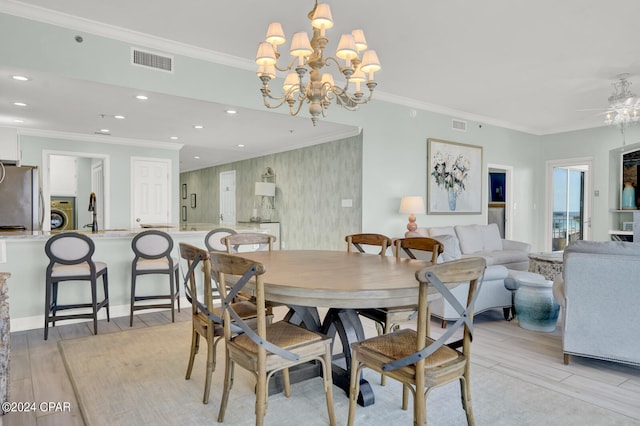 dining space with washer / clothes dryer, crown molding, ceiling fan with notable chandelier, and light wood-type flooring