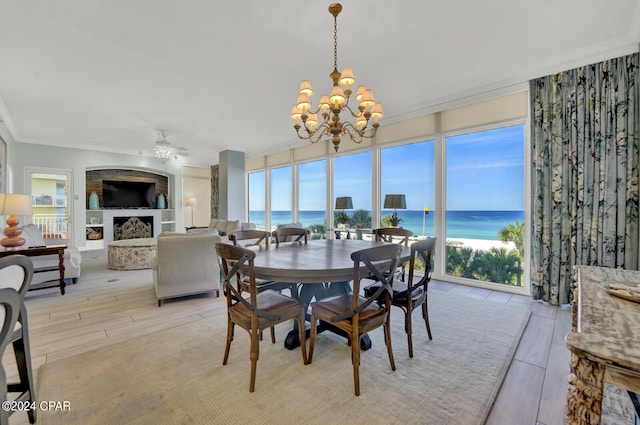 dining space featuring crown molding, ceiling fan with notable chandelier, and light hardwood / wood-style flooring