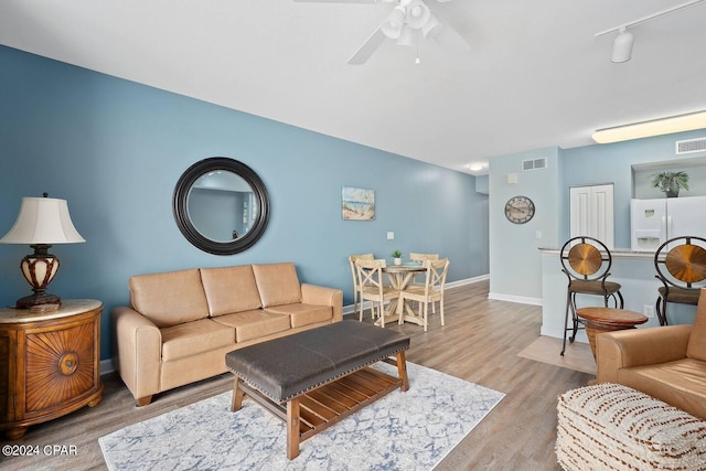 living room featuring track lighting, hardwood / wood-style flooring, and ceiling fan