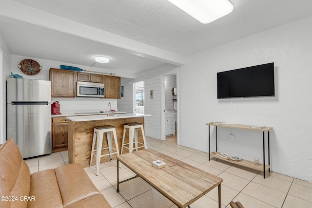 living area featuring a textured ceiling and light tile patterned flooring