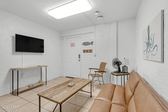 living room with a textured ceiling and light tile patterned flooring