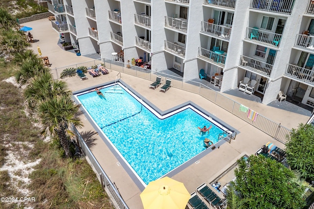 community pool with a patio and fence