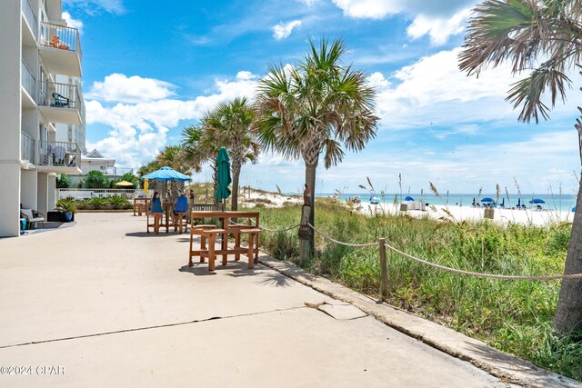 view of home's community featuring a view of the beach, a patio area, and a water view