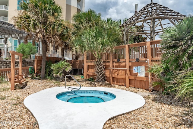 view of pool with an in ground hot tub and fence