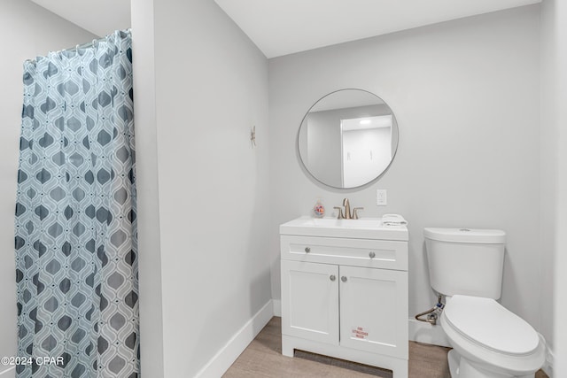 bathroom featuring vanity, wood finished floors, toilet, baseboards, and a shower with shower curtain