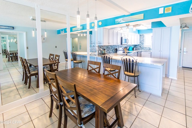 tiled dining room featuring a textured ceiling