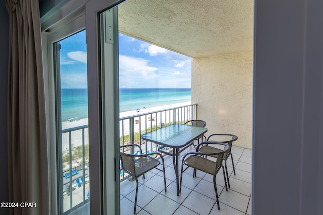 balcony featuring a water view and a view of the beach