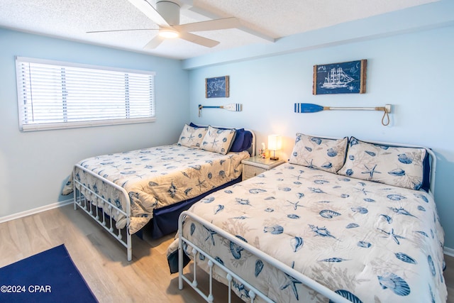 bedroom featuring ceiling fan, a textured ceiling, and light hardwood / wood-style flooring