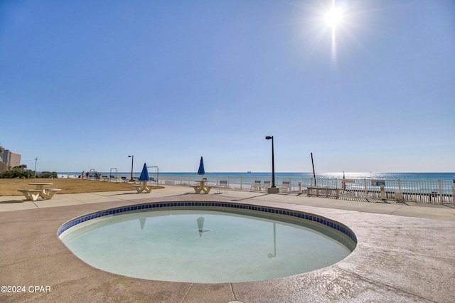 view of swimming pool featuring a water view and a patio area