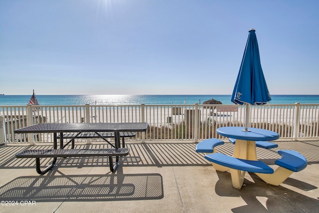 view of patio featuring a view of the beach and a water view