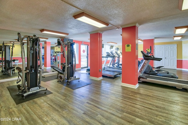 workout area featuring hardwood / wood-style flooring and a textured ceiling