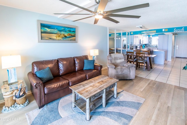 living room featuring a textured ceiling, light hardwood / wood-style flooring, and ceiling fan