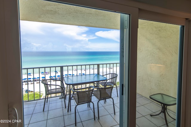 balcony featuring a view of the beach and a water view