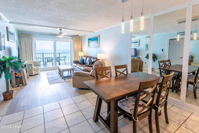 dining space featuring a textured ceiling, ceiling fan, and light hardwood / wood-style floors