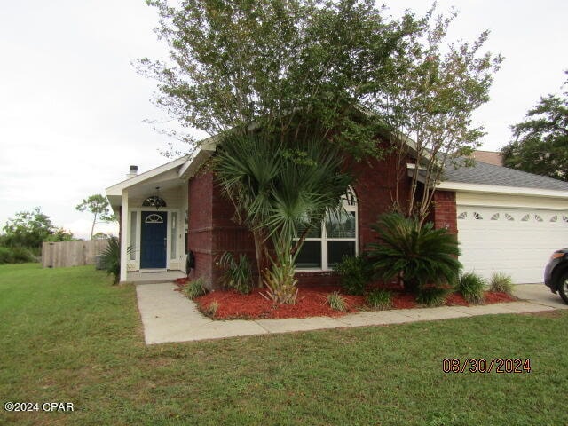 ranch-style house featuring a garage and a front lawn