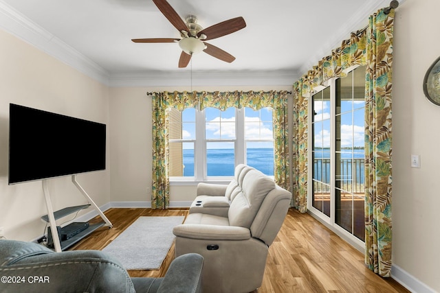 living room with ornamental molding, a water view, ceiling fan, and light hardwood / wood-style floors